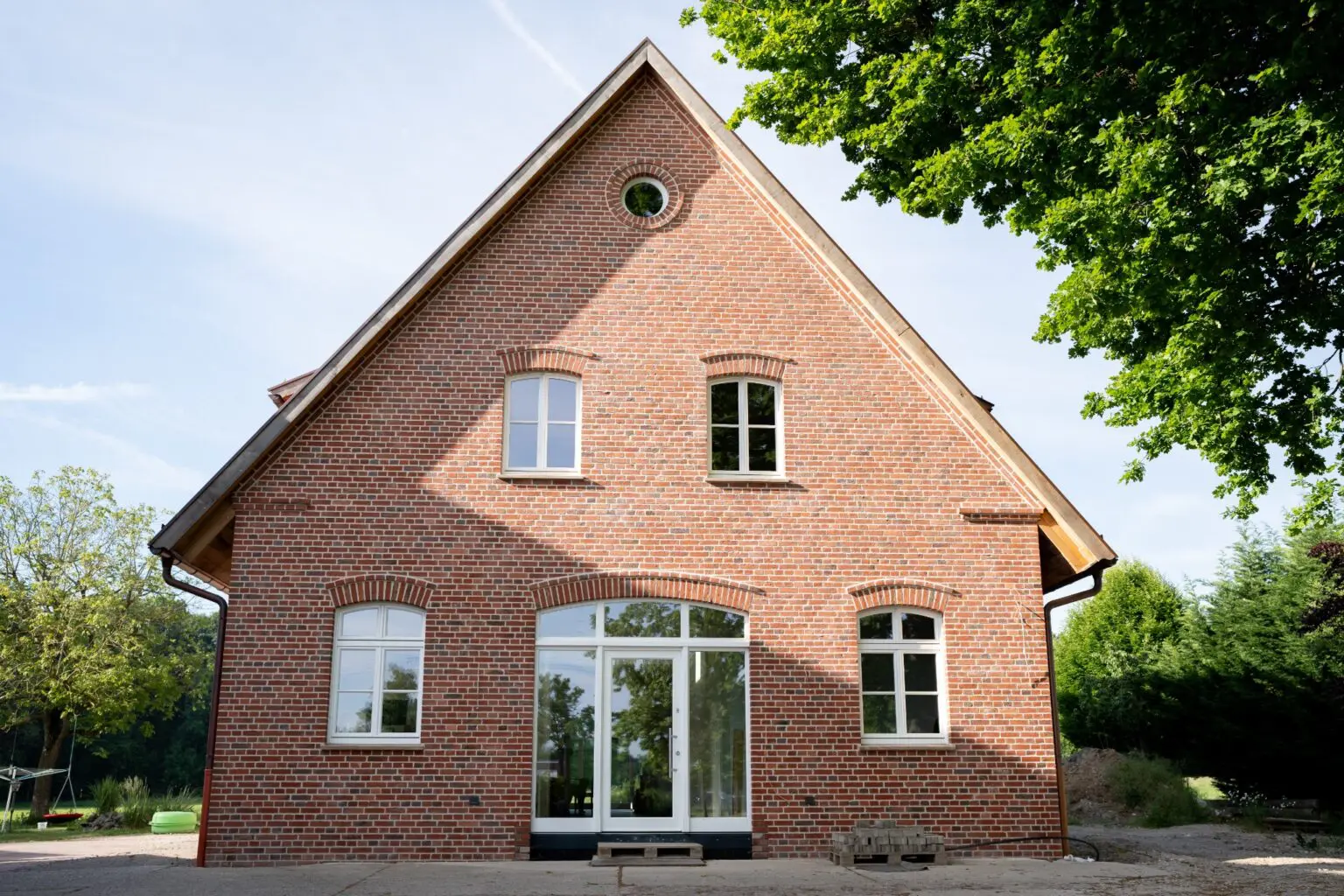 Klinkerneubau in Ennigerloh mit weißen klassischen Rundbogenfenstern und Türen